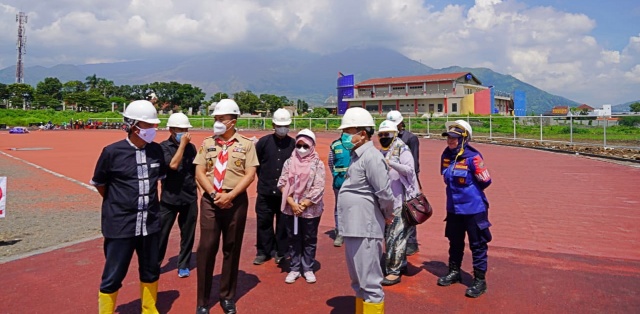 Garut. – NUANSA POST Dalam rangkaian kunjungannya ke Komplek Gelanggang Olah Raga (GOR) Dalem Adiwijaya, Bupati Garut, Rudy Gunawan, menyempatkan meninjau perkembangan pembangunan Stadion Kanjeng Dalem Adiwijaya, yang berlokasi di Jalan Proklamasi, Kecamatan Tarogong Kidul, Kabupaten Garut, Kamis (23/12/2021). Menurut bupati, sampai saat ini pembangunan Stadion Kanjeng Dalem Adiwijaya masih on progress, lintasan atletik berkualitas import ini rencananya rampung akhir tahun 2022. “Sampai hari ini on progress , ini adalah lintasan (atletik) impor, cek jangan berteriak-teriak di jalan, cek ke sini kalau sayang pada Garut, ayo kita transparankan, lihat ini adalah lapangan sepak bola, yang disini kemarin sudah diuji tidak terjadi genangan (bahkan) ketika hujan cukup lebat tidak terjadi genangan, ini 6 bulan masa pemeliharaan, ini sudah dipasang rumput, dan ini secara otomatis rumput itu akan terus dipelihara, nanti dipelihara, ini akan selesai insya Allah 2022 akhir, Desember 2022 insya Allah ini akan mendekati kesempurnaan, ” tegas Bupati Garut. Untuk pemasangan tribun dari Stadion Kanjeng Dalem Adiwijaya sendiri akan dilakukan di tahun 2022, dan diharapkan pada tahun 2023 stadion ini sudah bisa digunakan. “Stadion ini kan on the track (untuk) tahap pertama, tahap keduanya tahun depan ini mau membangun tribun, (stadion bisa dipakai) 2023.” tandasnya.(HENDRA)***