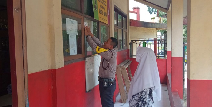 Dukung Program Quick Wins Presisi, Bhabinkamtibmas Desa Cibahayu Pasang Stiker Kontak Person di Sekolah