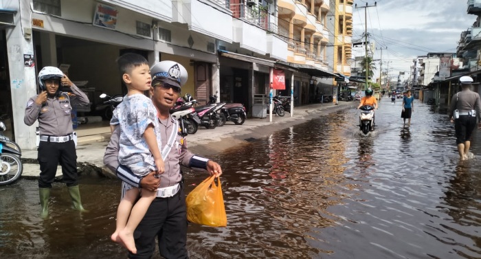 Wujud Polisi Peduli Keselamatan, Personel Satlantas Bantu Warga Lewati Jalan Terendam Banjir