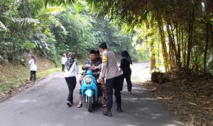 Bersama Warga, Bhabinkamtibmas Desa Madiasari Gotong Royong Bersihkan Jalan Cipancur