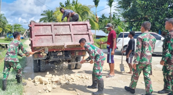 Personel Satgas Yonif 122/TS Bersama Masyarakat Gotong-Royong Perbaiki Jalan Rusak